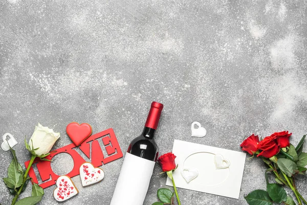 Bottle of wine, rose flowers, hearts and word LOVE on grey table. Valentine\'s Day celebration