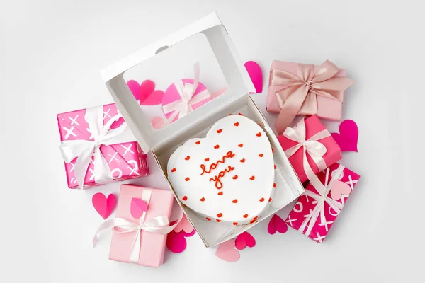 Box with heart-shaped bento cake, gifts and hearts isolated on white background. Valentine\'s Day celebration