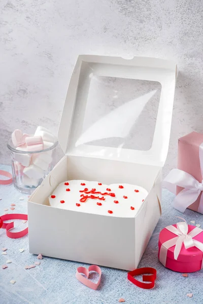 Box with tasty bento cake, gifts and hearts on grey table. Valentine\'s Day celebration