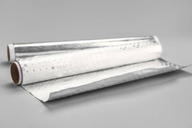 Rolls of aluminium foil on grey background