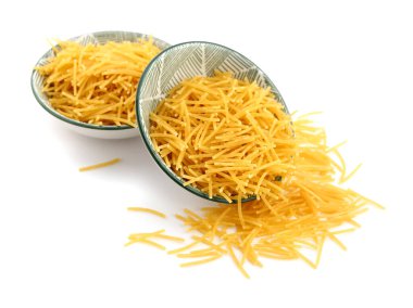 Bowls of raw vermicelli pasta on white background