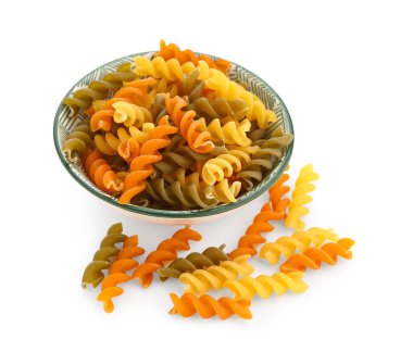 Bowl of raw fusilli pasta on white background