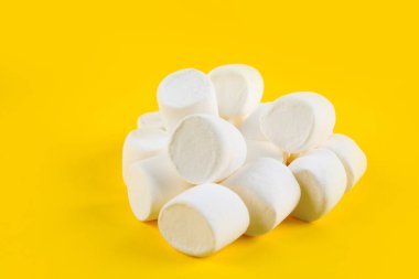 Heap of tasty marshmallows on yellow background