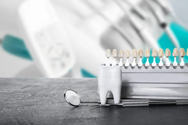 Teeth color chart with dental tools on table in clinic