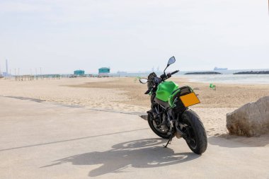 Modern motorcycle parked on city beach