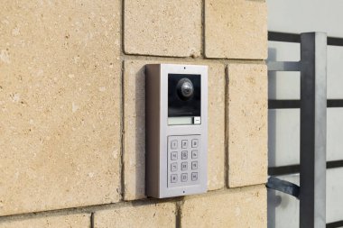Modern intercom on brick wall