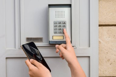 Child with mobile phone using intercom outdoors, closeup