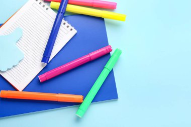 Notebooks and felt-tip pens on color background, closeup