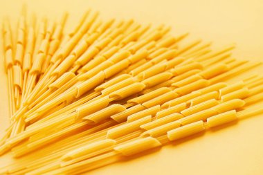 Composition with raw pasta on color background, closeup