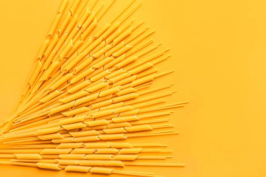 Composition with raw pasta on color background