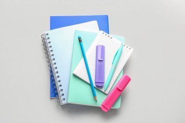Notebooks, pen, pencil and markers on light background