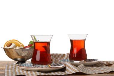 Glass cups of Turkish tea on wooden table against white background
