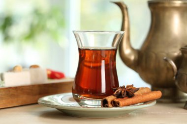 Plate with cup of Turkish tea and spices on table