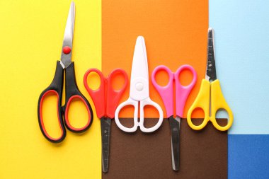 Set of scissors on color background