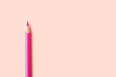 Pink pencil on color background