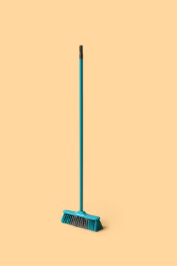 Blue cleaning broom on orange background