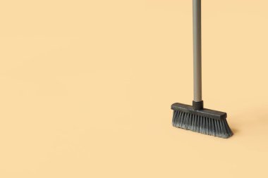Broom for cleaning on orange background