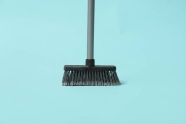 Plastic sweeping broom on color background
