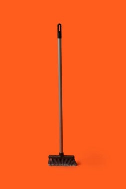 Plastic cleaning broom on color background