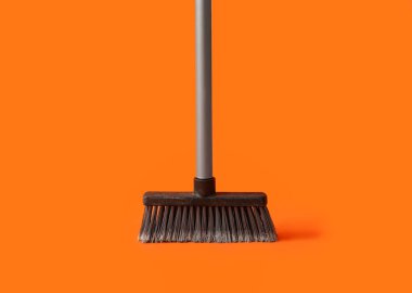 Plastic cleaning broom on color background