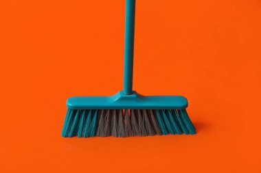 Plastic broom for cleaning on color background