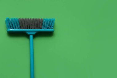 Blue cleaning broom on green background