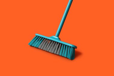 Plastic broom for cleaning on color background