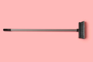 Plastic cleaning broom on pink background