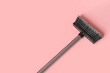 Plastic cleaning broom on pink background