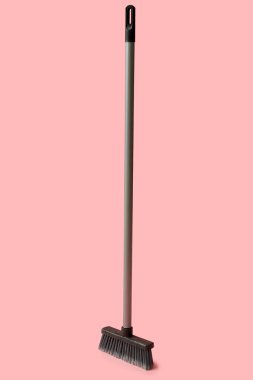 Plastic cleaning broom on pink background