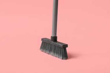 Plastic cleaning broom on pink background