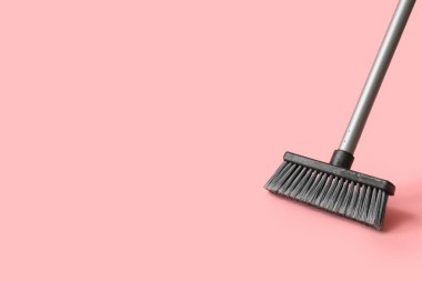 Plastic cleaning broom on pink background