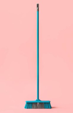 Broom for cleaning on pink background