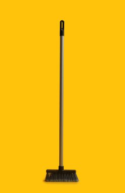 Plastic cleaning broom on yellow background