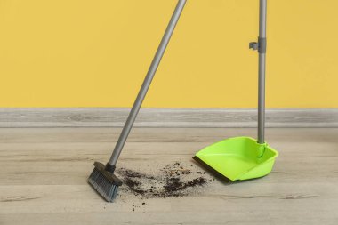 Sweeping of rubbish with dustpan and broom on floor