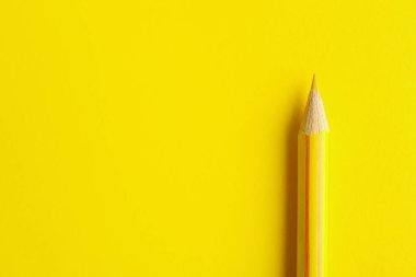 Yellow pencil on color background