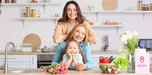 Mutlu genç bir kadın, küçük kızı ve annesi evde. Uluslararası Kadınlar Günü kutlamaları