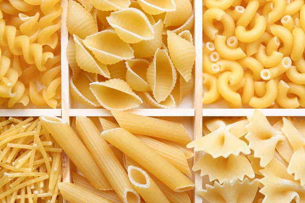 Box with different types of raw pasta, closeup