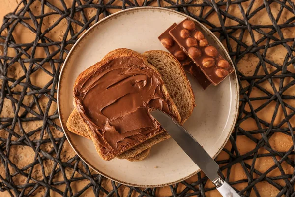 Plate of tasty toasts with hazelnut butter and chocolate on table
