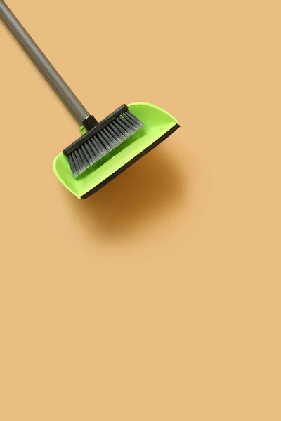 Cleaning broom with dustpan on color background