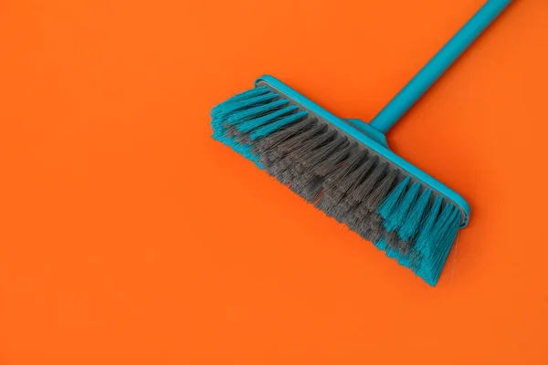Blue broom for cleaning on color background