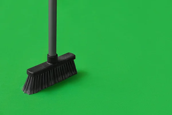 Cleaning broom on green background