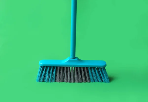 Plastic cleaning broom on green background