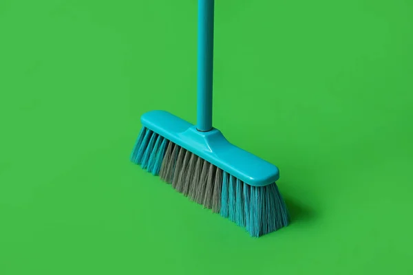 Plastic cleaning broom on green background