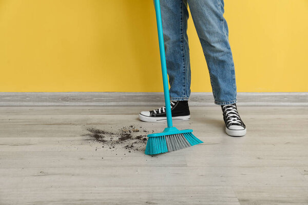 Woman sweeping rubbish with broom