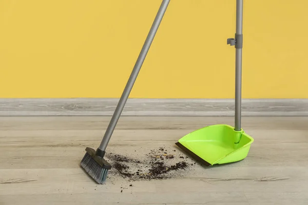 Sweeping of rubbish with dustpan and broom on floor