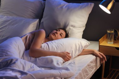 Beautiful woman lying in bed at night