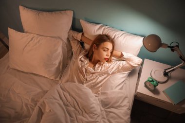 Young woman cannot sleep in bedroom at night