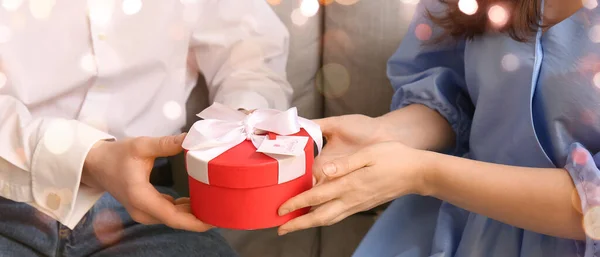 Woman receiving gift from her boyfriend, closeup. Valentine\'s Day celebration