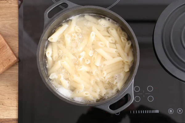 Cooking pot with boiling pasta on electric stove